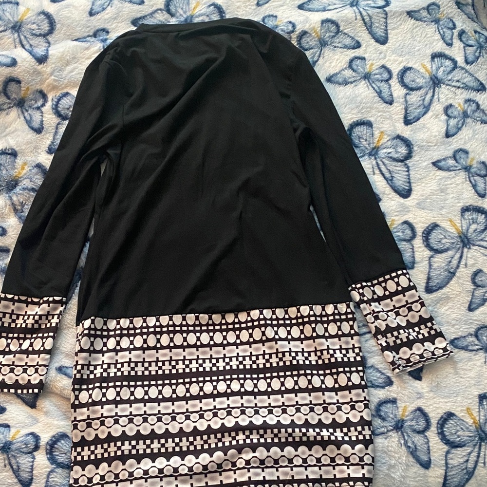 Black midi dress with unique design on bottom and arm cuffs for any occasion